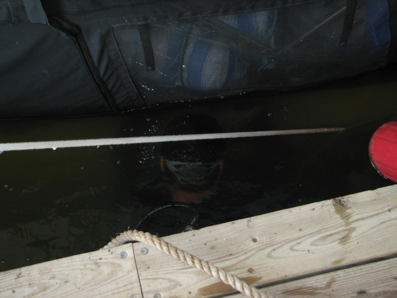 Diver working in between the boat and the dock.