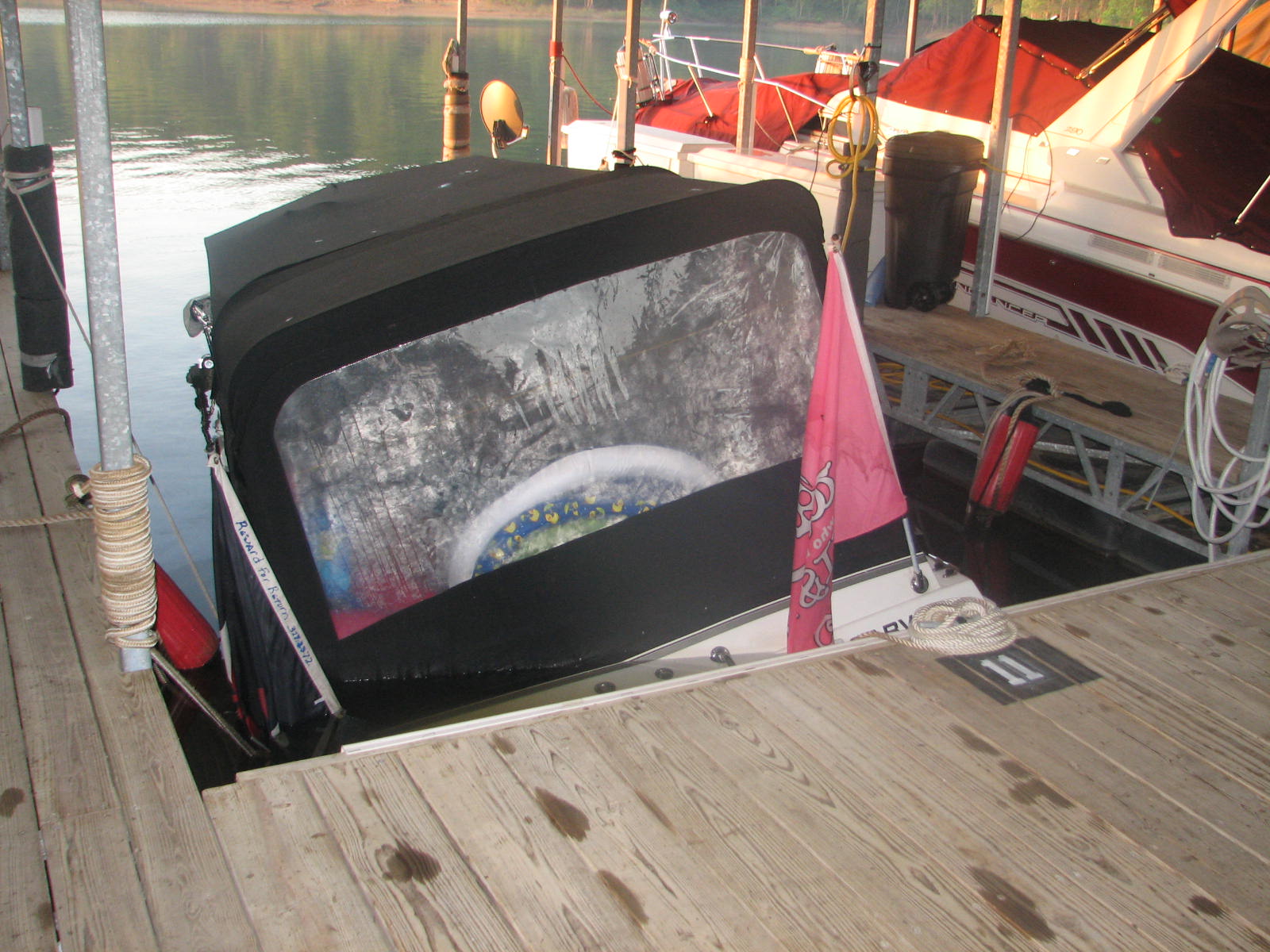 Boat partway raised inside of the dock slip.