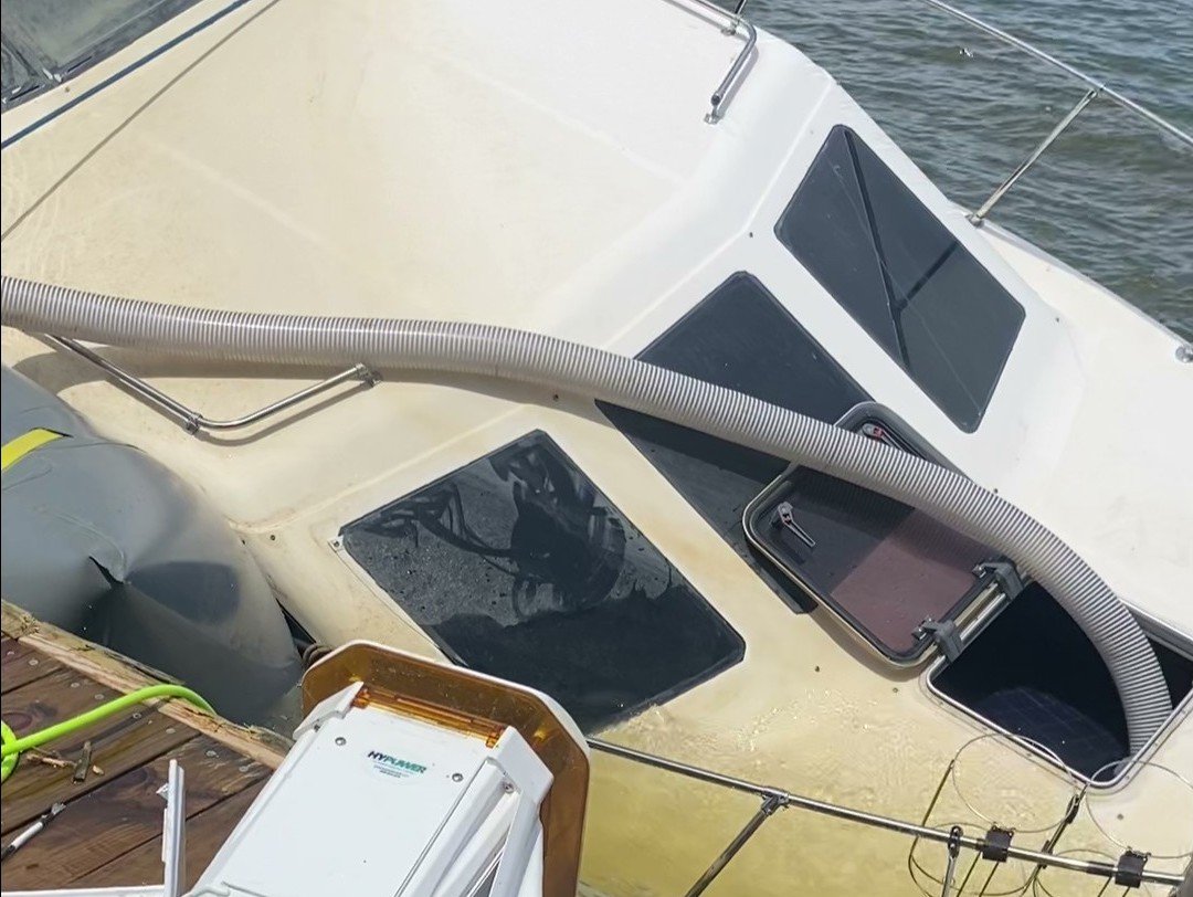 Boat being pumped out after being raised by lift bags.