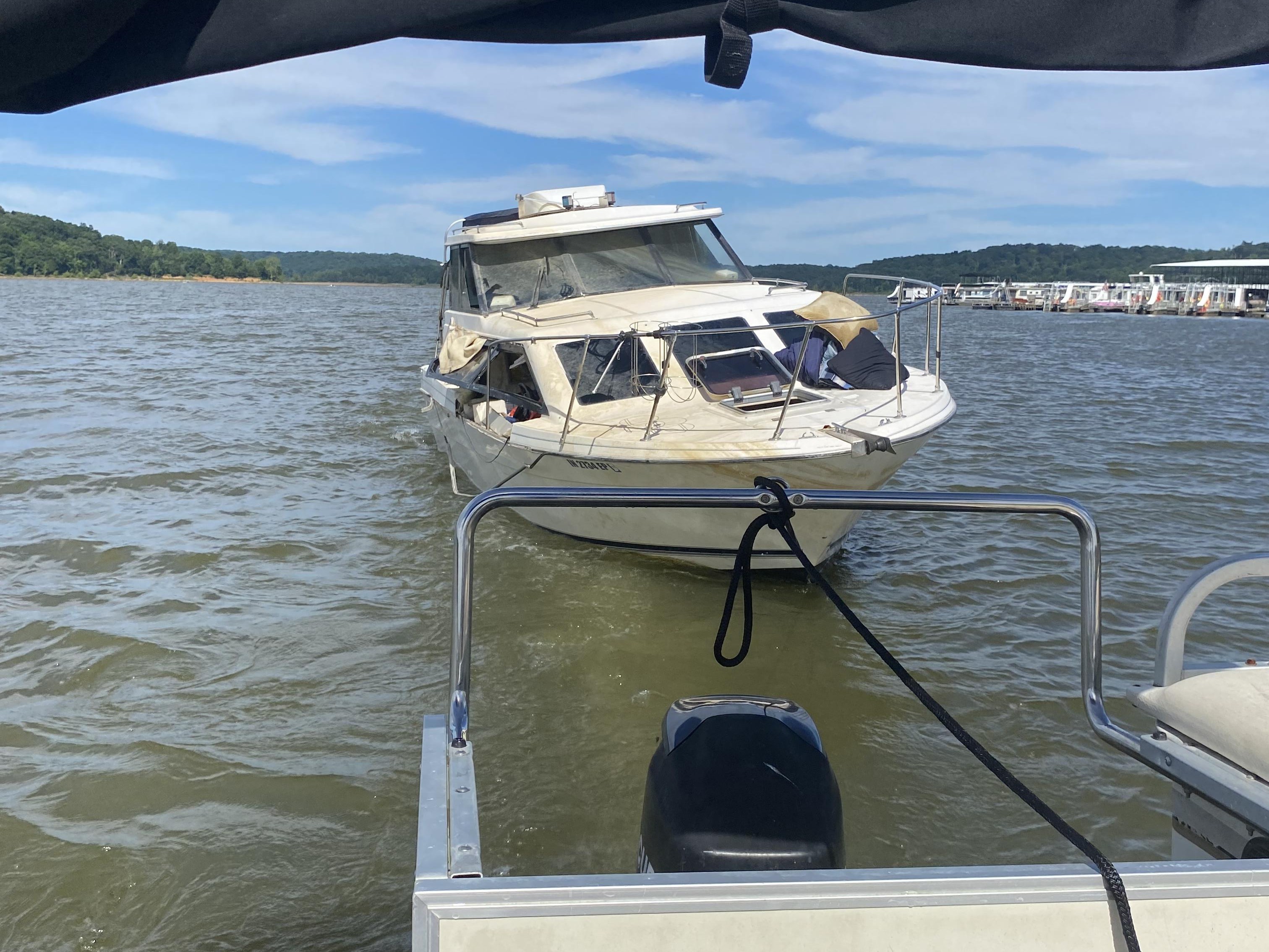 Boat being towed to boat ramp where trailer is waiting.