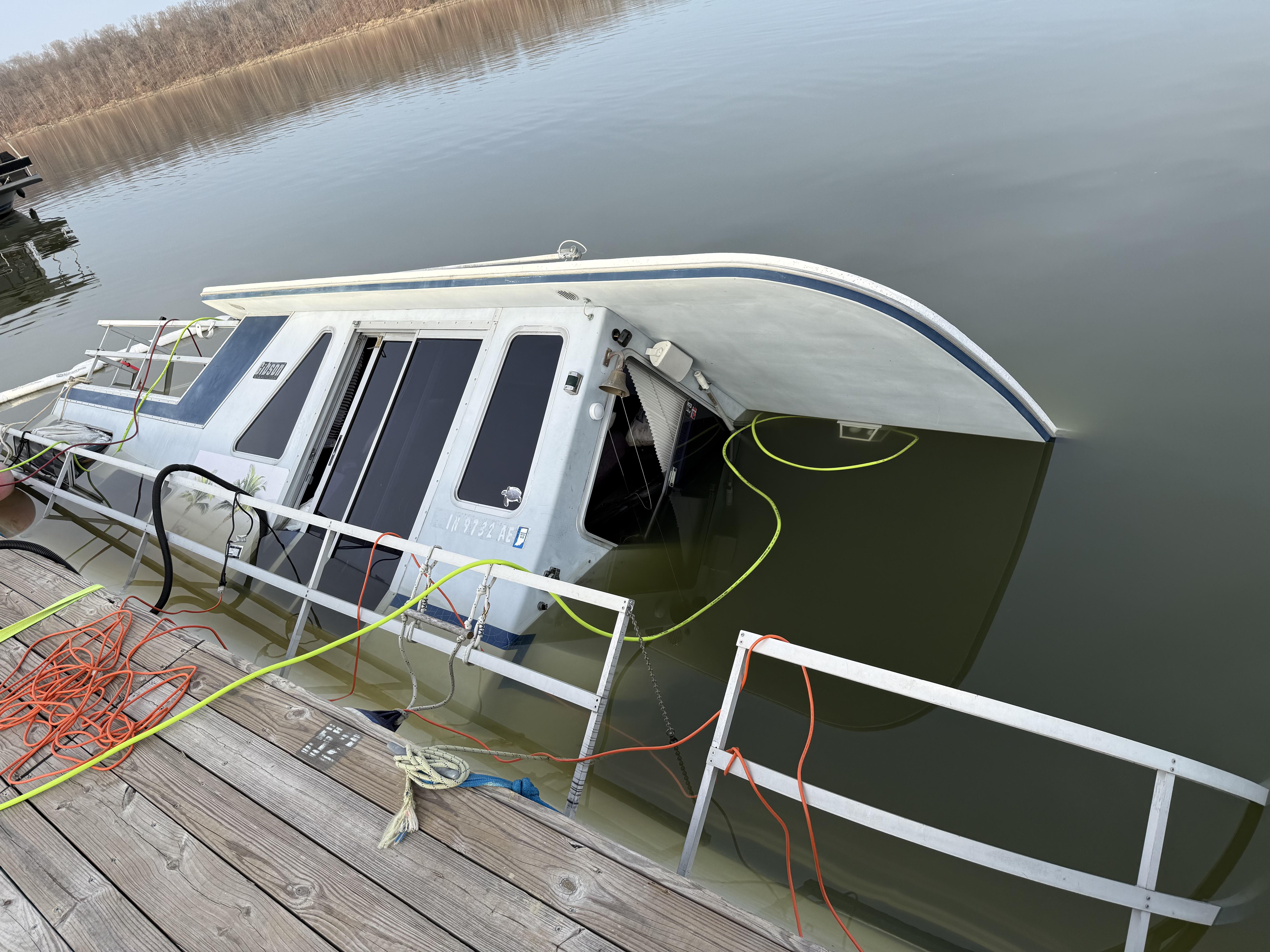 Boat resting on it's side on the lake bed with Lift bags attached.